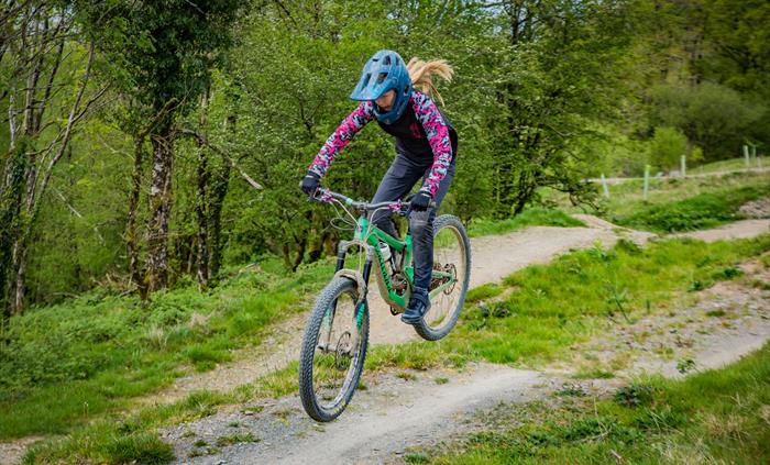 Action shot of a young female rider jumping a table top jump